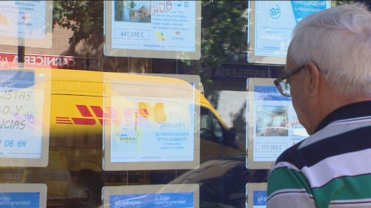 Un hombre observa anuncios de venta de pisos