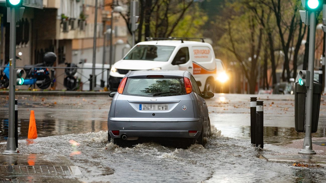 Un coche circula por una balsa de agua, en la Avenida de la Ciudad de Barcelona