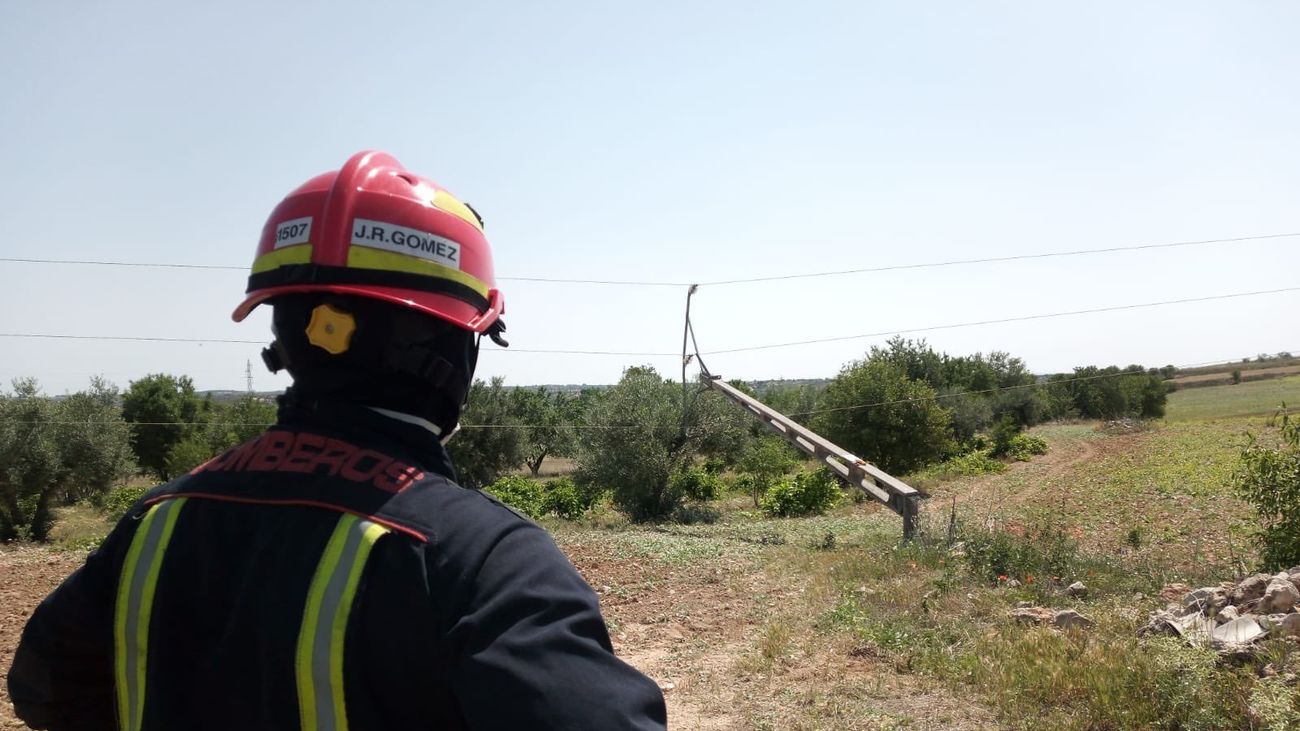 Un bombero cerca del poste de alta tensión caído sobre el olivo,  en Villarejo de Salvanés
