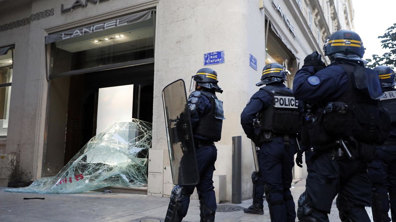 Agentes de Policía junto a un comercio vandalizado en Marsella