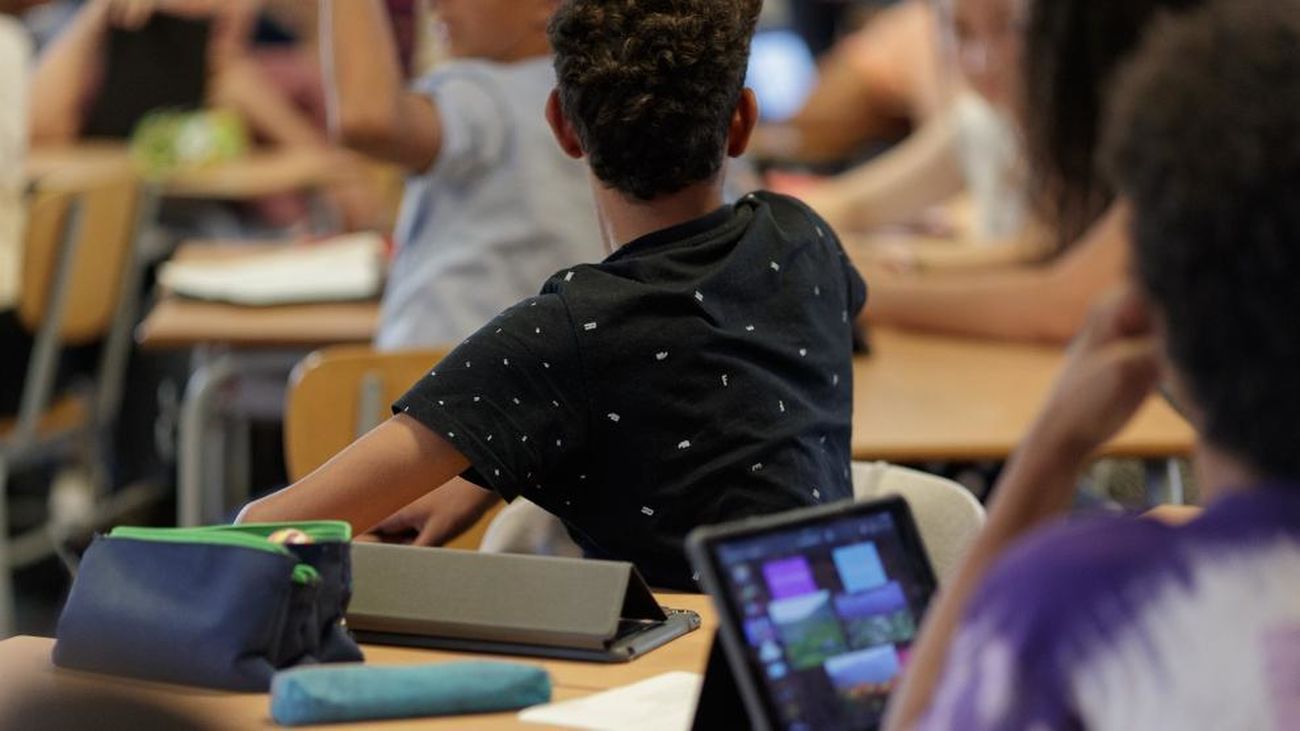 Alumnos con tabletas electrónicas en el aula