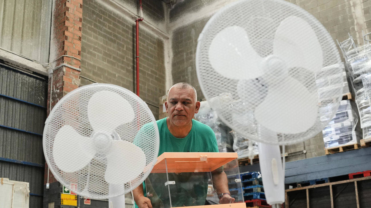 Un operario traslada urnas y ventiladores