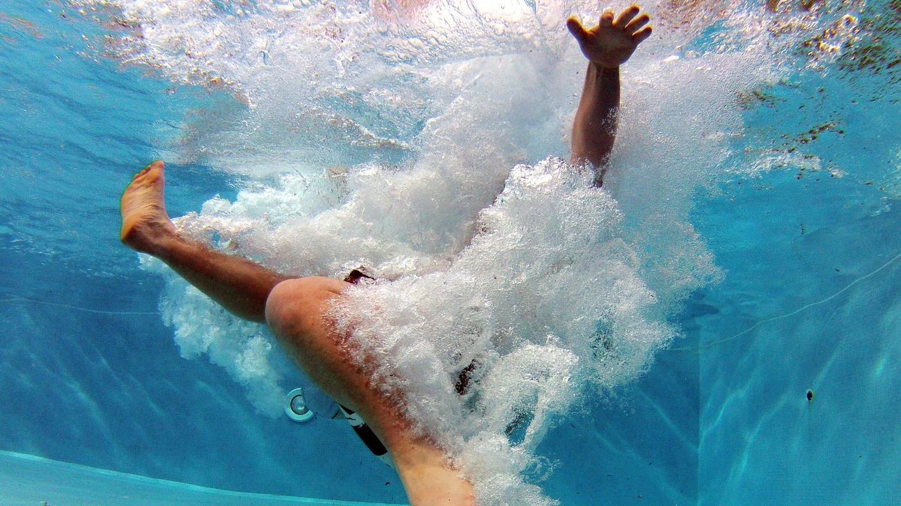 Foto de una persona sumergida en el agua de una piscina