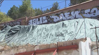Vecinos de la Ronda de Segovia piden que se retire la lona contra incendios sobre la muralla de Madrid
