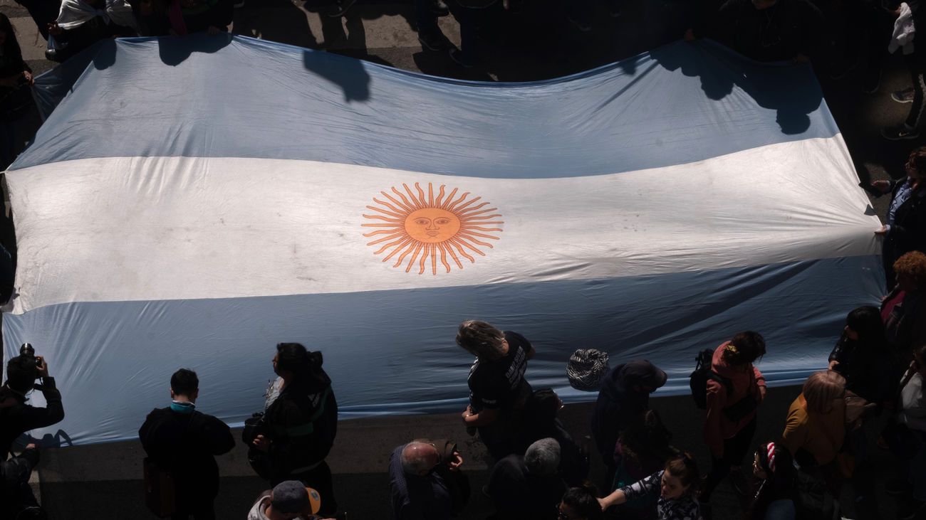Varias personas transportan una bandera de Argentina