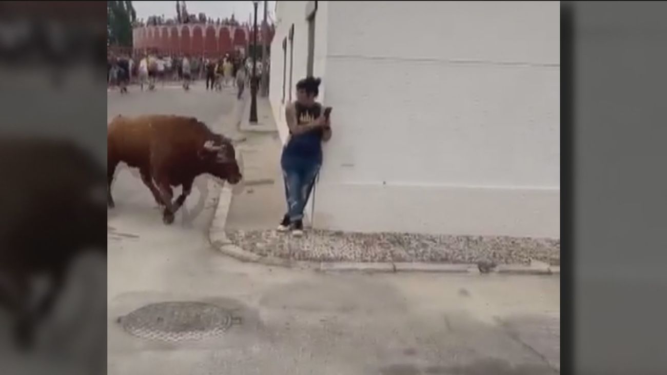 Un toro embiste a una joven que estaba mirando el móvil en un encierro