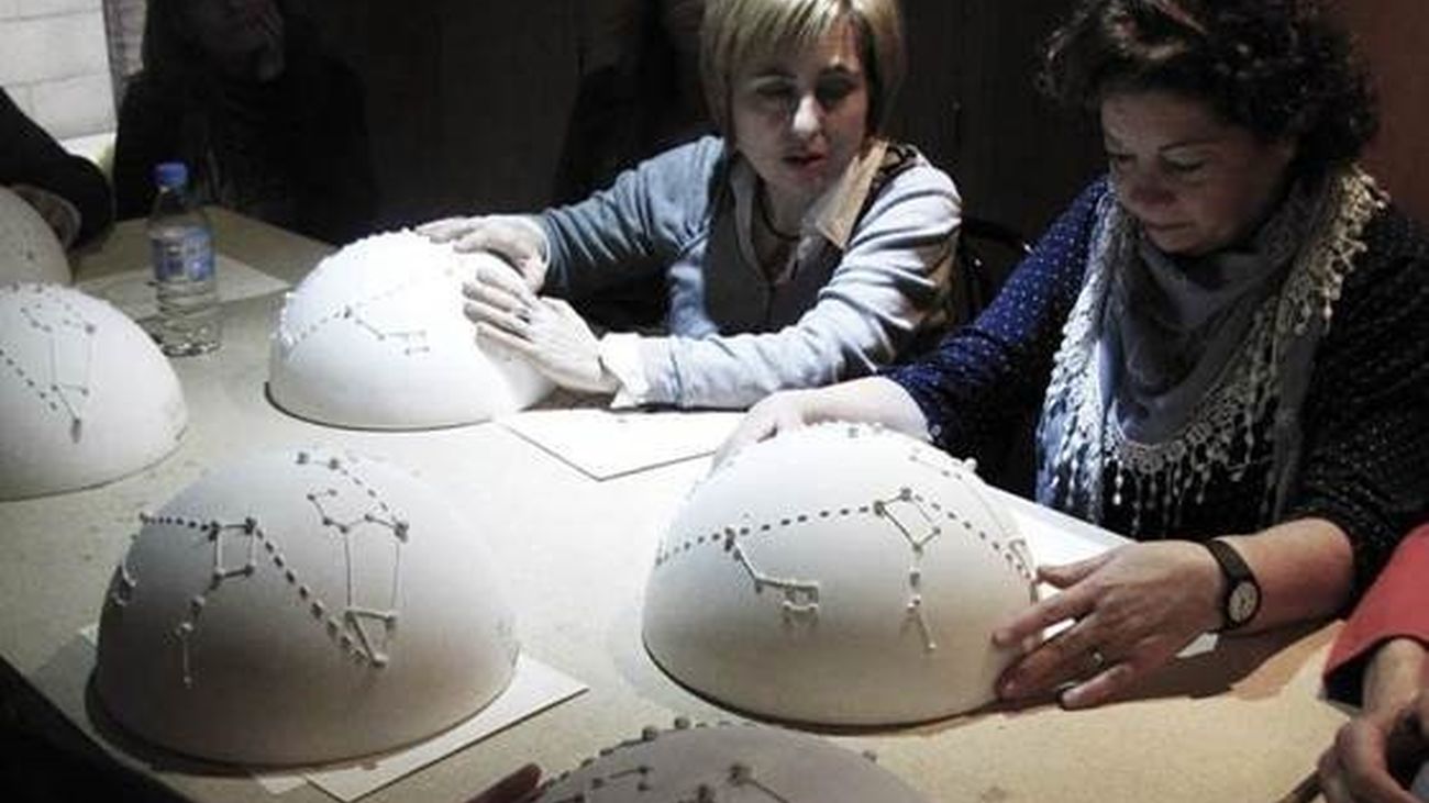 Dos personas con esferas celestes tiflológicas