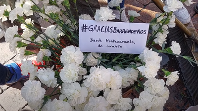 Vecinos de Montecarmelo llevan claveles blancos a la estatua del barrendero de la Plaza de Benavente