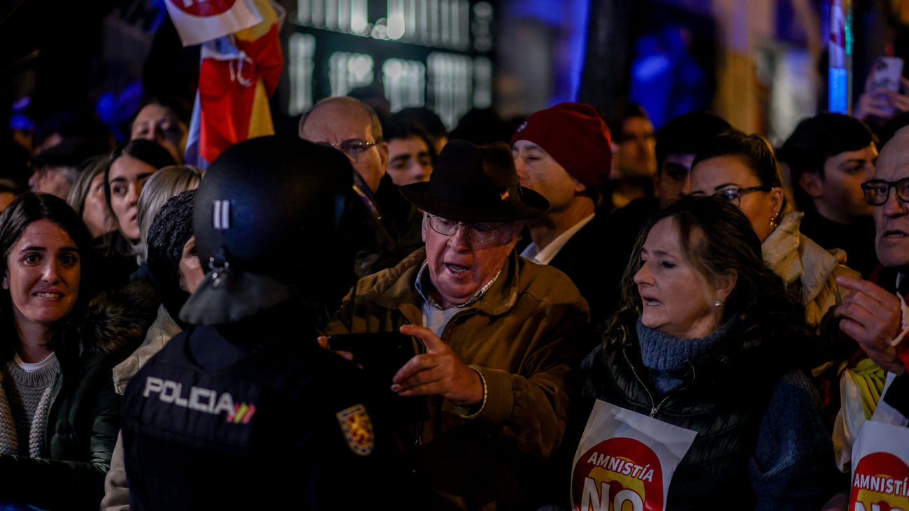 Varias personas durante una concentración en contra de la amnistía, frente a la sede del PSOE en la calle Ferraz,