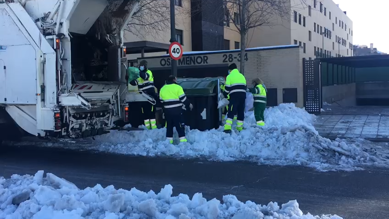 Operarios municipales  retiran la nieve depositada en una avenida de Móstoles