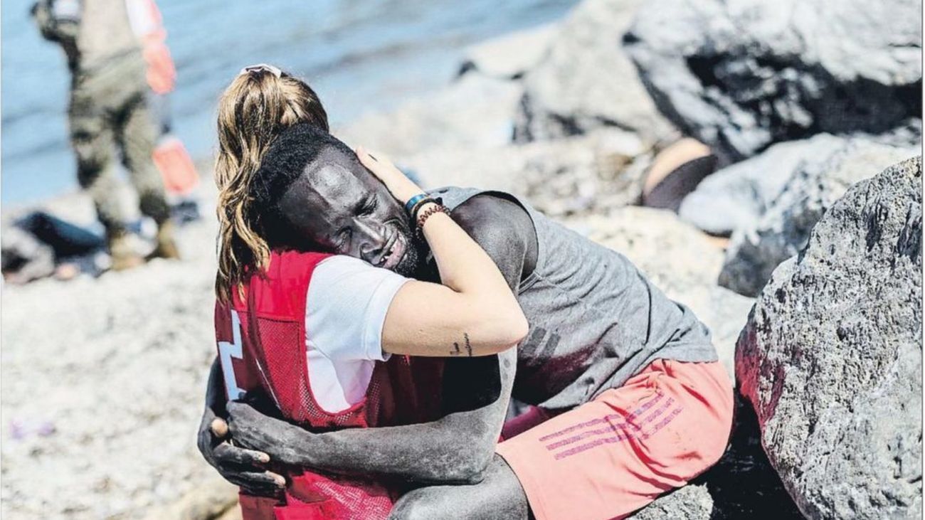 Luna Reyes, voluntaria de Cruz Roja, abraza a Abdou en una playa de Ceuta en 2021