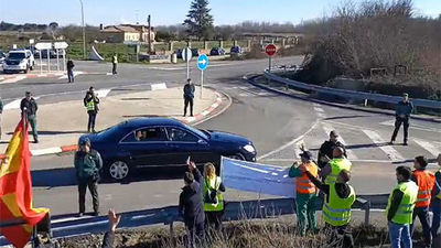 La reina Letizia saluda desde el coche a un grupo de agricultores a su llegada a Salamanca