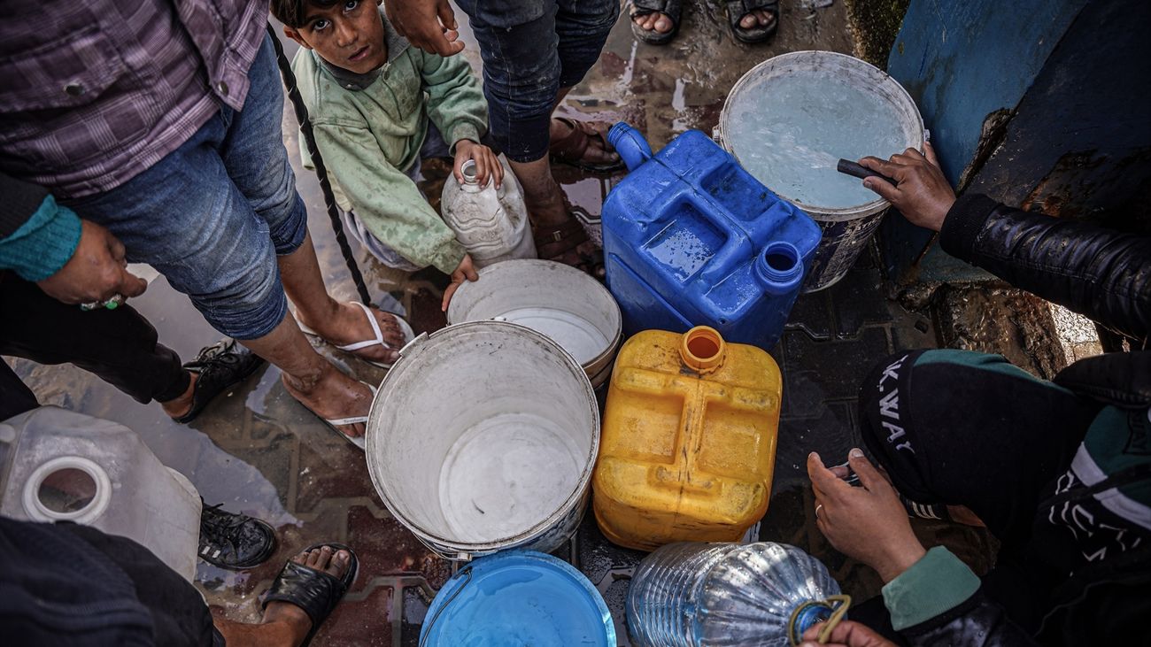 Población palestina de Gaza recoge agua en una estación de servicio