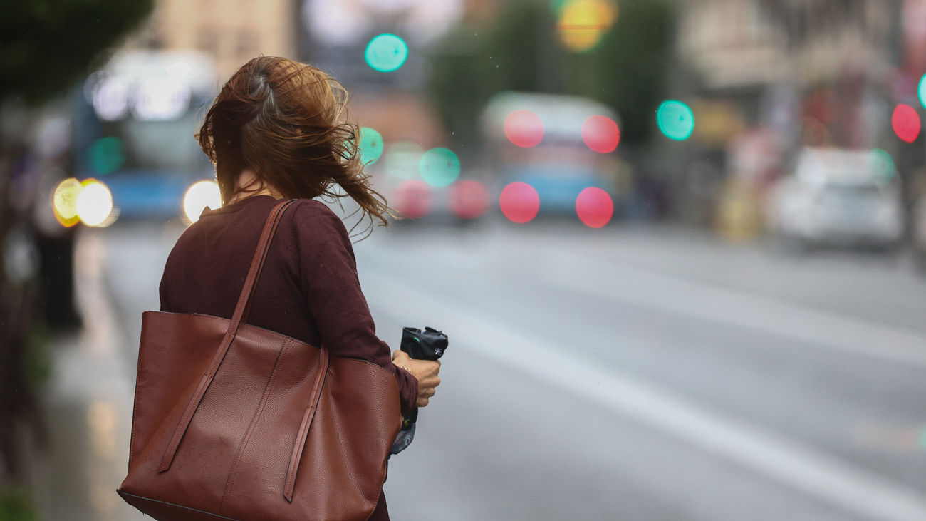 Una mujer se despeina por el aire en la calle Gran Vía