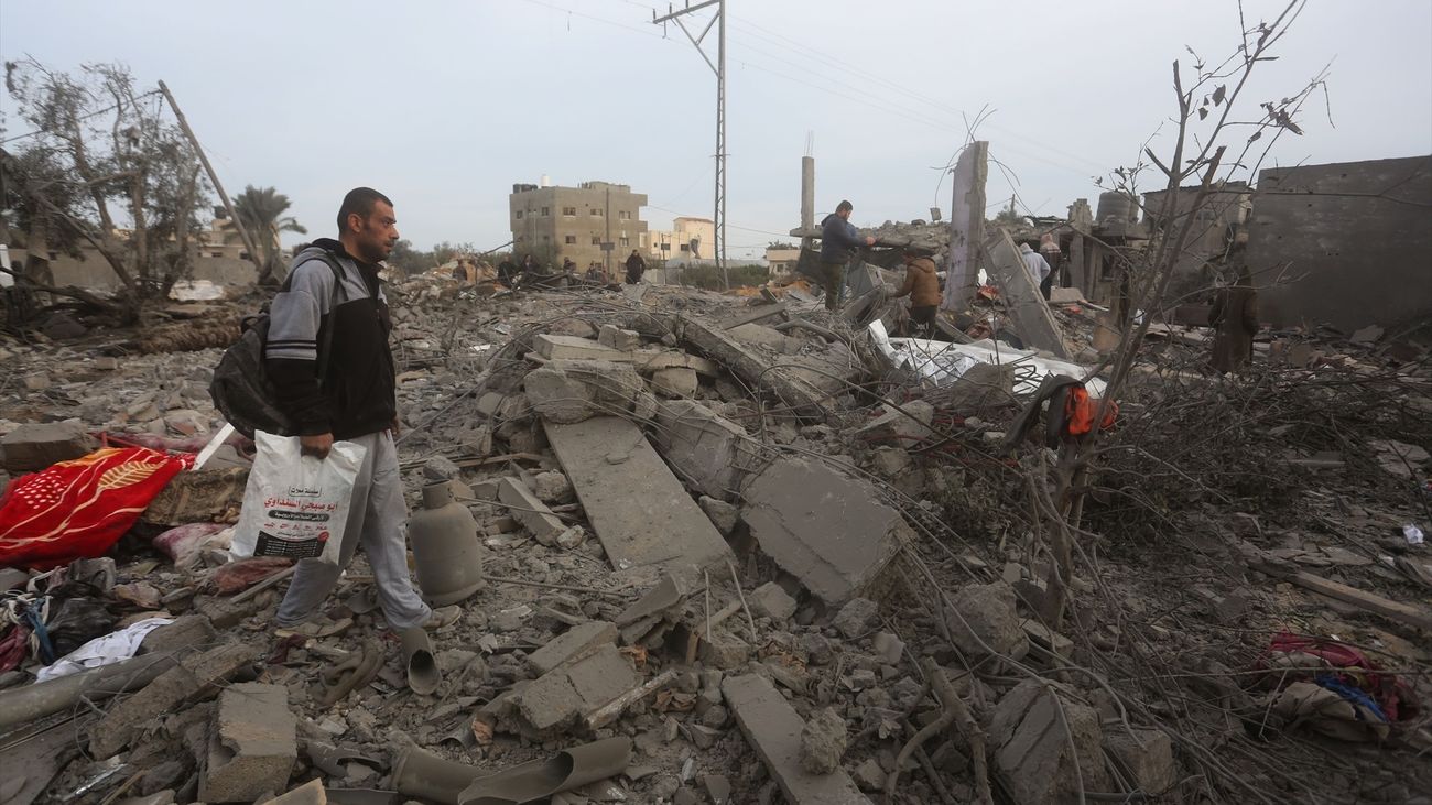 Varios palestinos entre los escombros de un edificio destruido por los ataques del Ejército de Israel