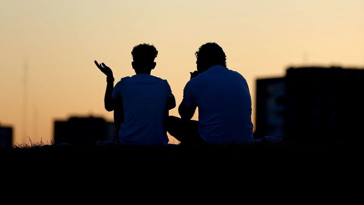 Dos personas conversan sentadas en el Cerro del Tío Pío / Cézaro De Luca / Europa Press