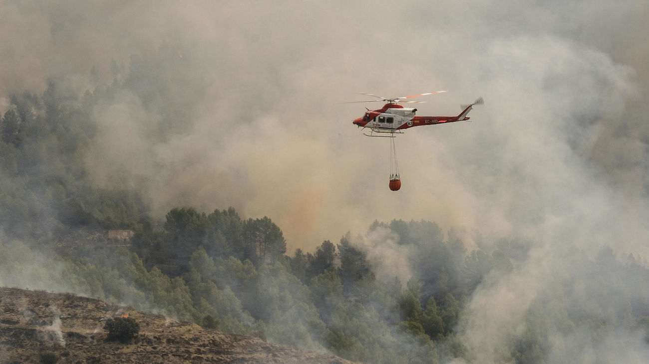Un helicóptero trabaja en la extinción del incendio forestal de Tárbena, Alicante