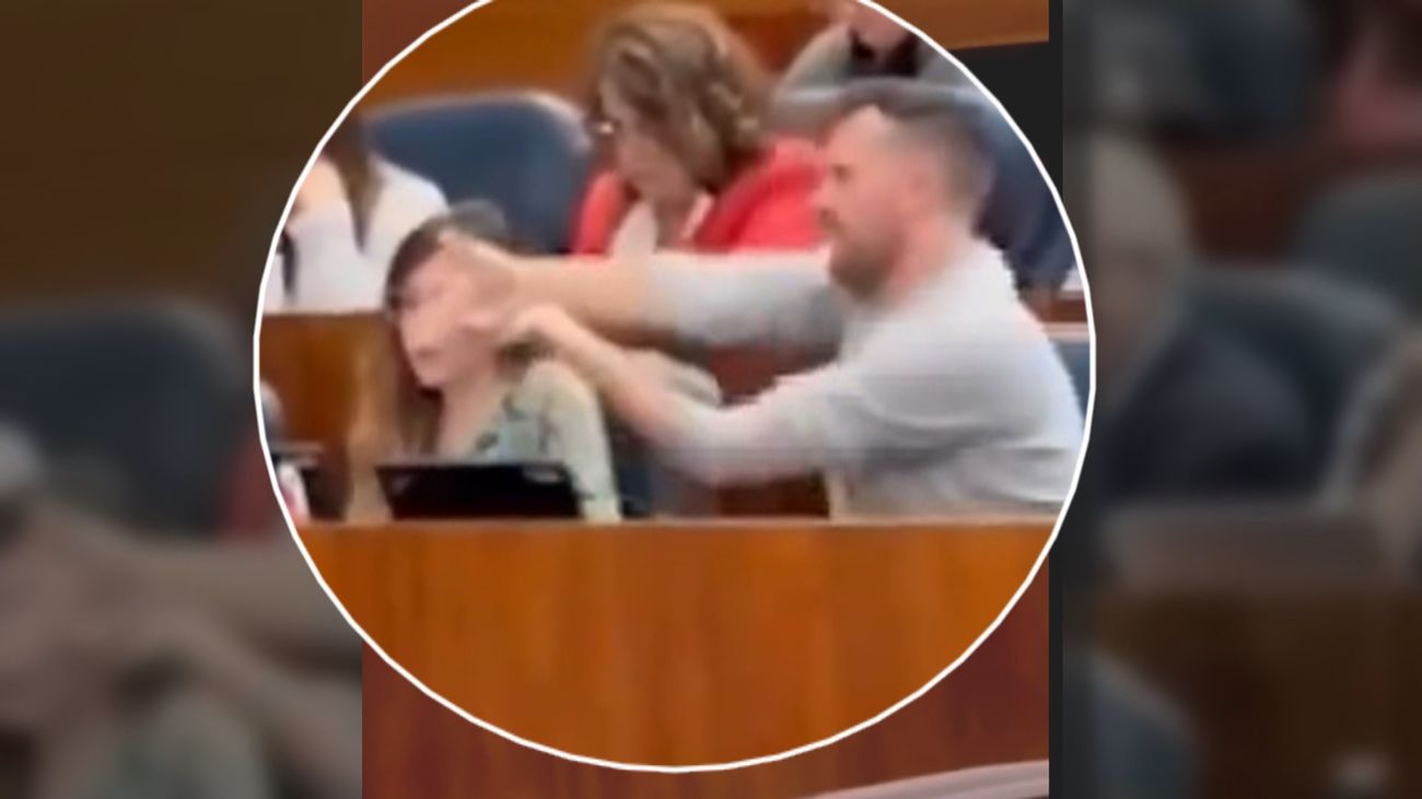 Pablo Padilla de Más Madrid hace gestos de disparar durante la intervención de Ayuso