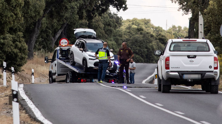 Una grúa recoge el vehículo en el que fue tiroteado un hermano de Begoña Villacís, en la carretera de Fuencarral-El Pardo