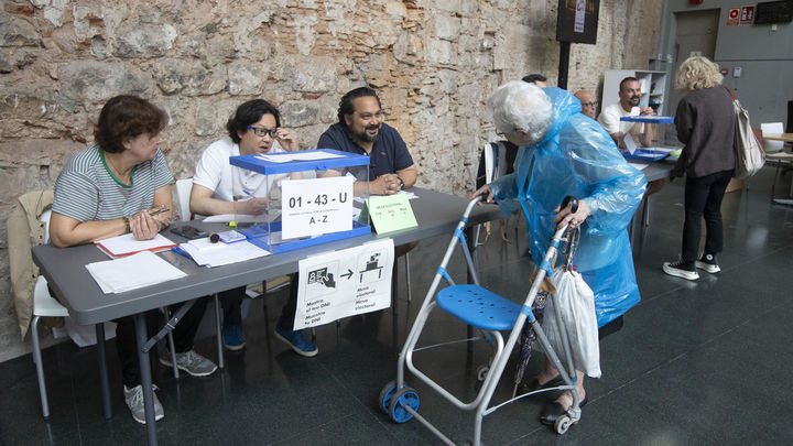 Una mujer se dispone a votar en el colegio electoral dispuesto en el Convento de San Agustí, en Barcelona / EFE