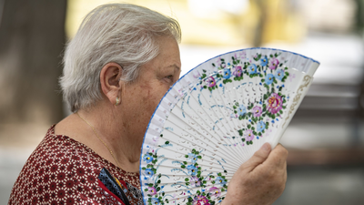 "Todo el día sudando y bebiendo estoy", los madrileños combaten el calor con agua, piscina y abanicos