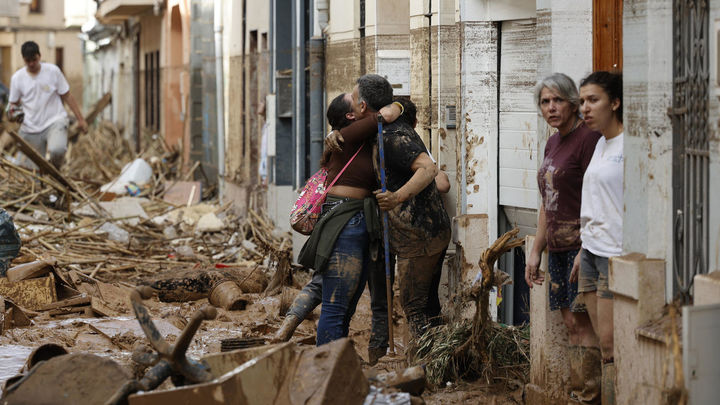 Varias personas en una calle destrozada tras el paso de la DANA en Valencia / EUROPA PRESS