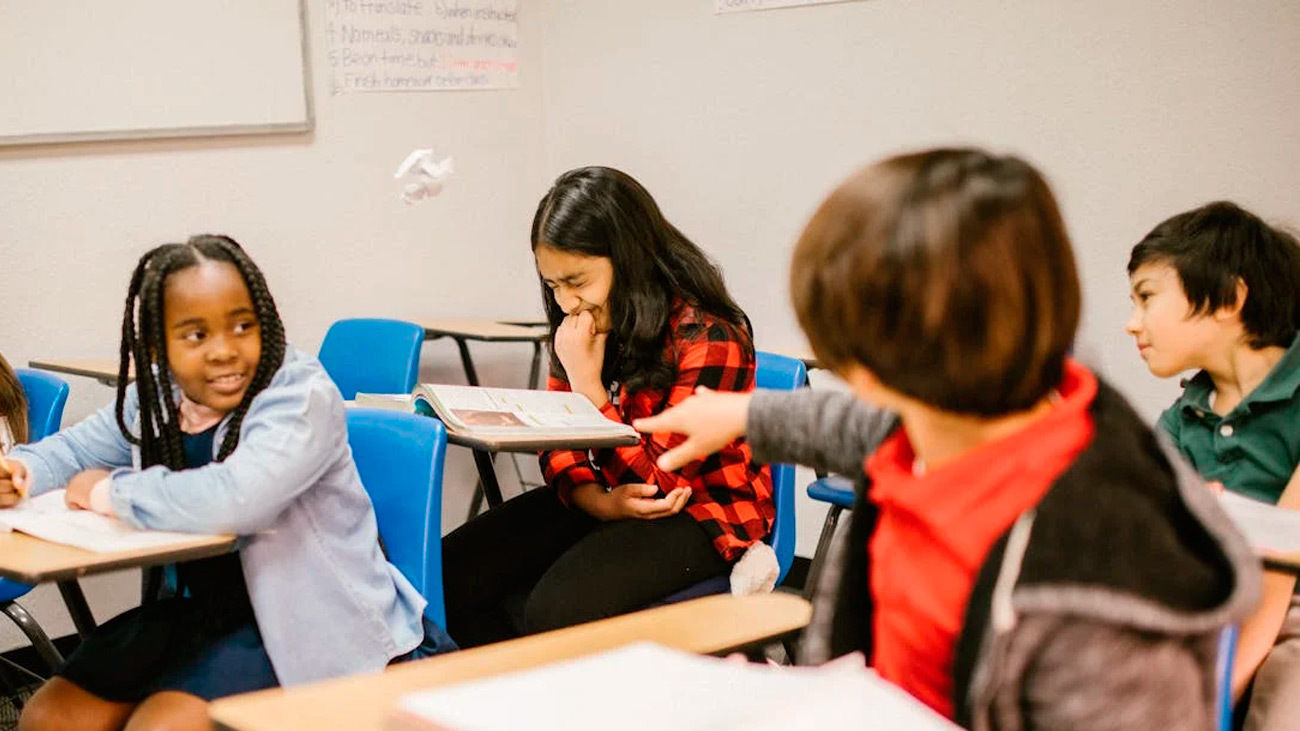 Un alumno le lanza una bola de papel a una compañera