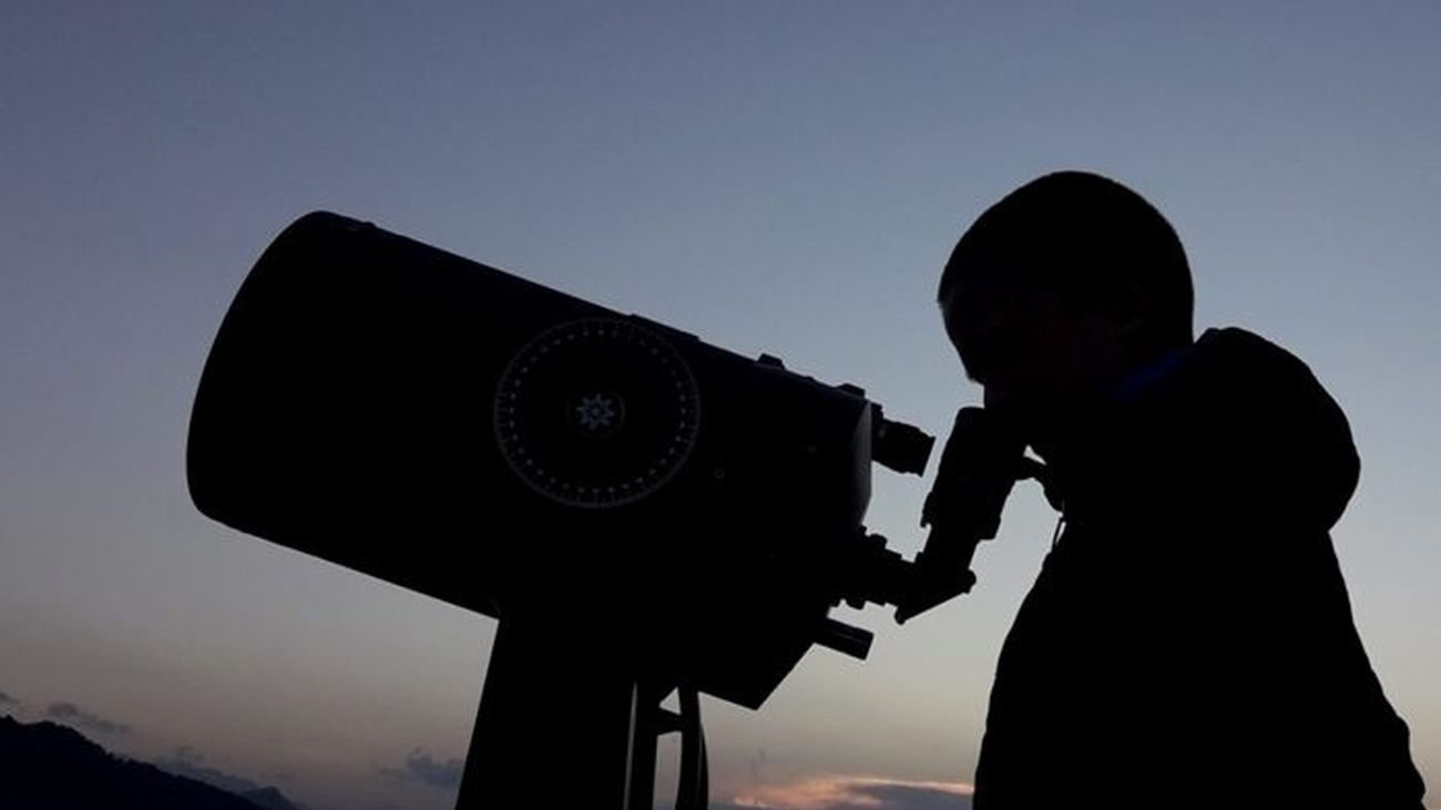 Una persona mira a través del ocular de un telescopio