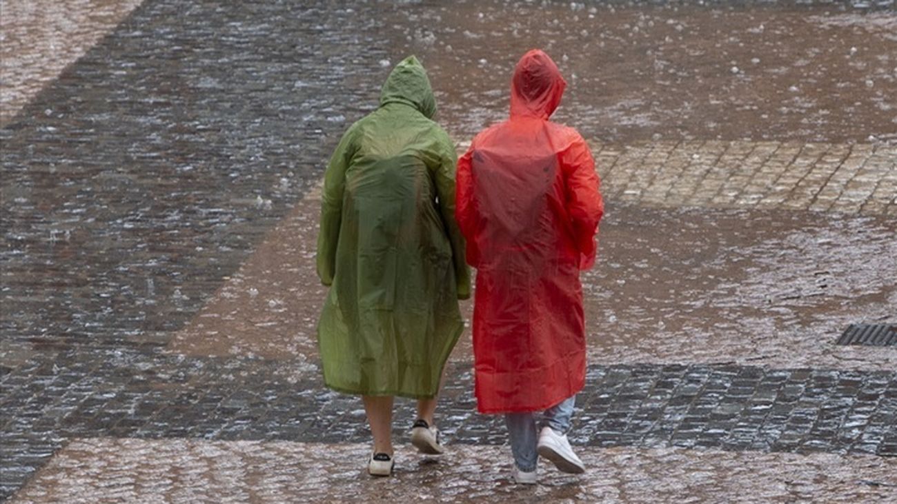 Dos personas se protegen de la lluvia con chubasqueros