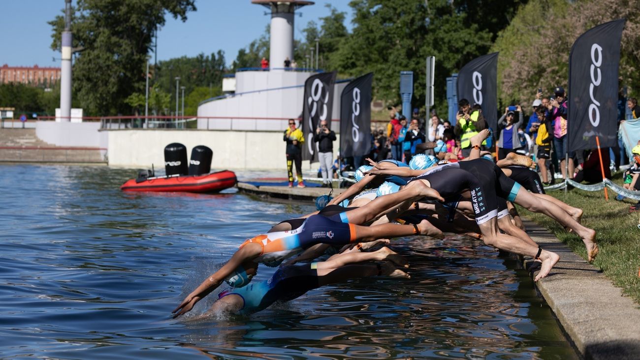 Deportistas se lanzan al Lago del Parque Central durante la celebración del Triatlón de Tres Cantos