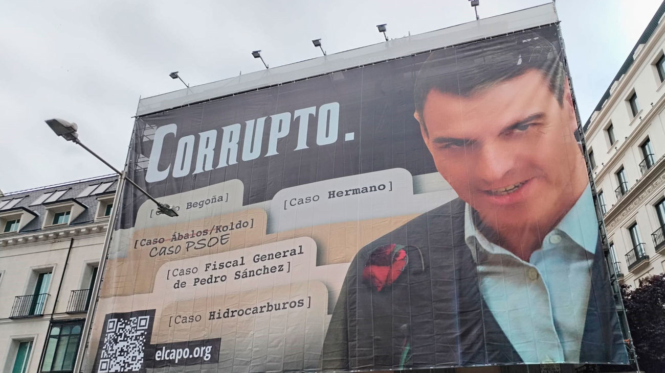 Hazte Oír despliega una lona frente al Congreso con una imagen de Pedro Sánchez acompañado del lema "Corrupto"