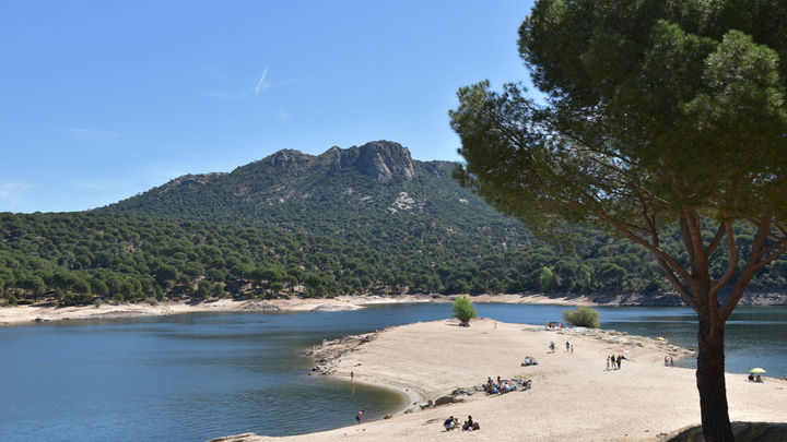 Varias personas toman el sol en la playa de la Virgen de la Nueva en el Pantano de San Juan / Comunidad de Madrid
