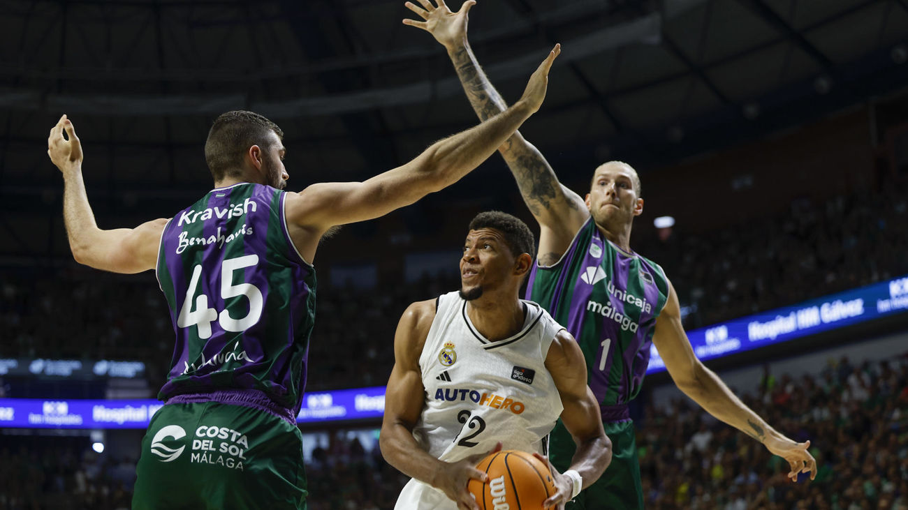 El madridista Edy Tavares, ante dos jugadores del Unicaja