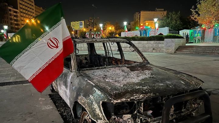 Un coche calcinado con la bandera de Irán, en Teherán / EUROPA PRESS