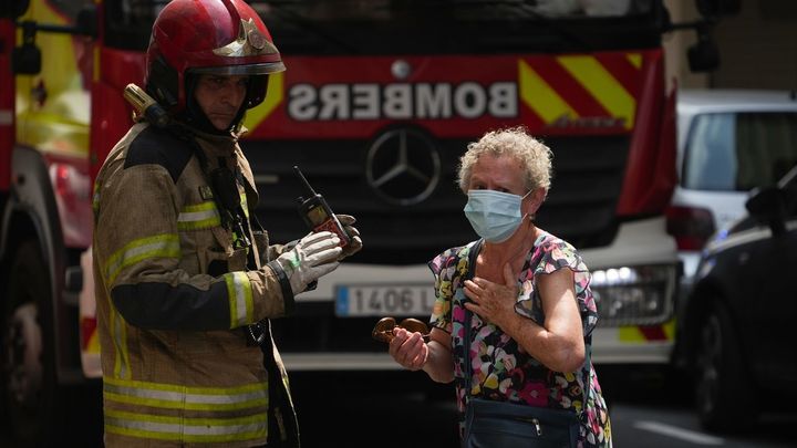 Un bombero atiende a una mujer durante un incendio en la avenida del Puerto, en Valencia / EUROPA PRESS