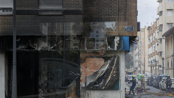 Bomberos trabajan en la extinción del local origen del incendio en la avenida del Puerto, en Valencia / EFE
