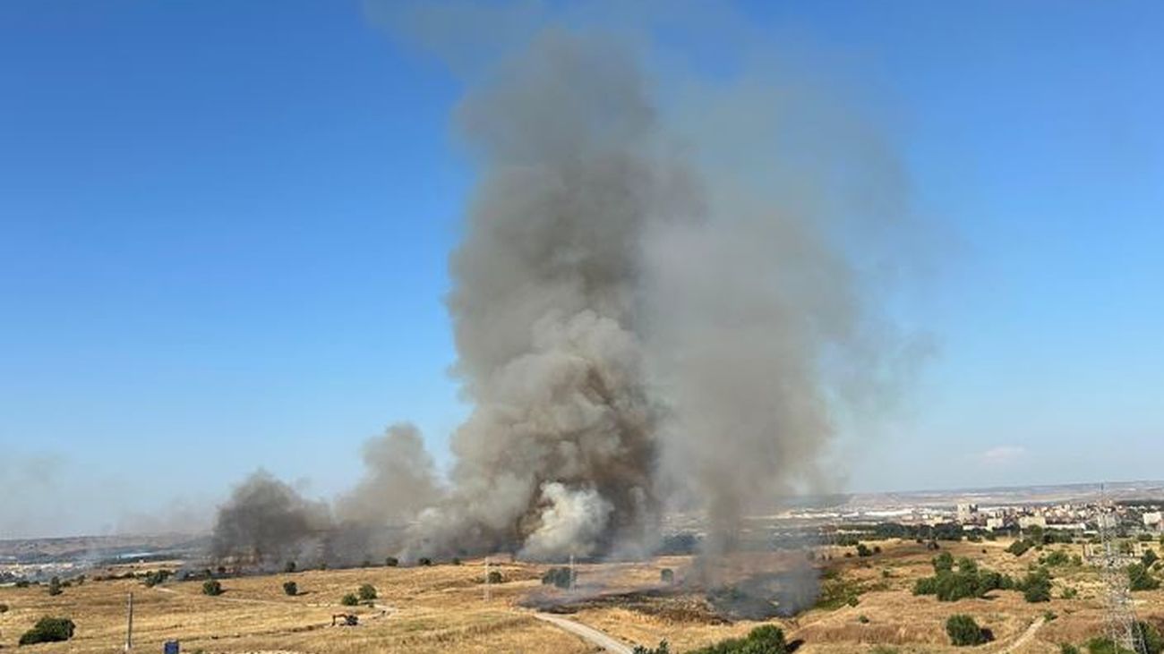 Un incendio de vegetación provoca una intensa y alta columna de humo cerca de la M-40, entre Barajas y Coslada
