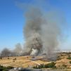 Un incendio de vegetación provoca una intensa y alta columna de humo cerca de la M-40, entre Barajas y Coslada