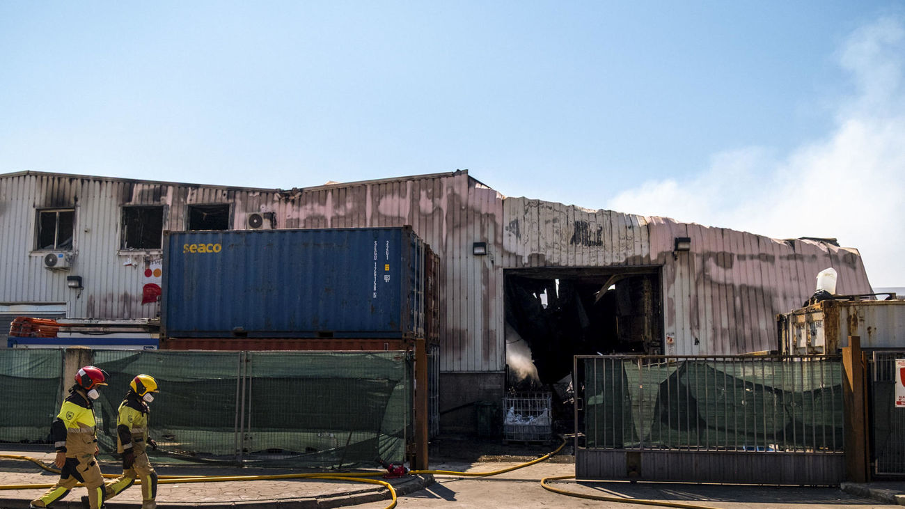 Bomberos caminan junto a la nave siniestrada en Azuqueca de Henares (Guadalajara)