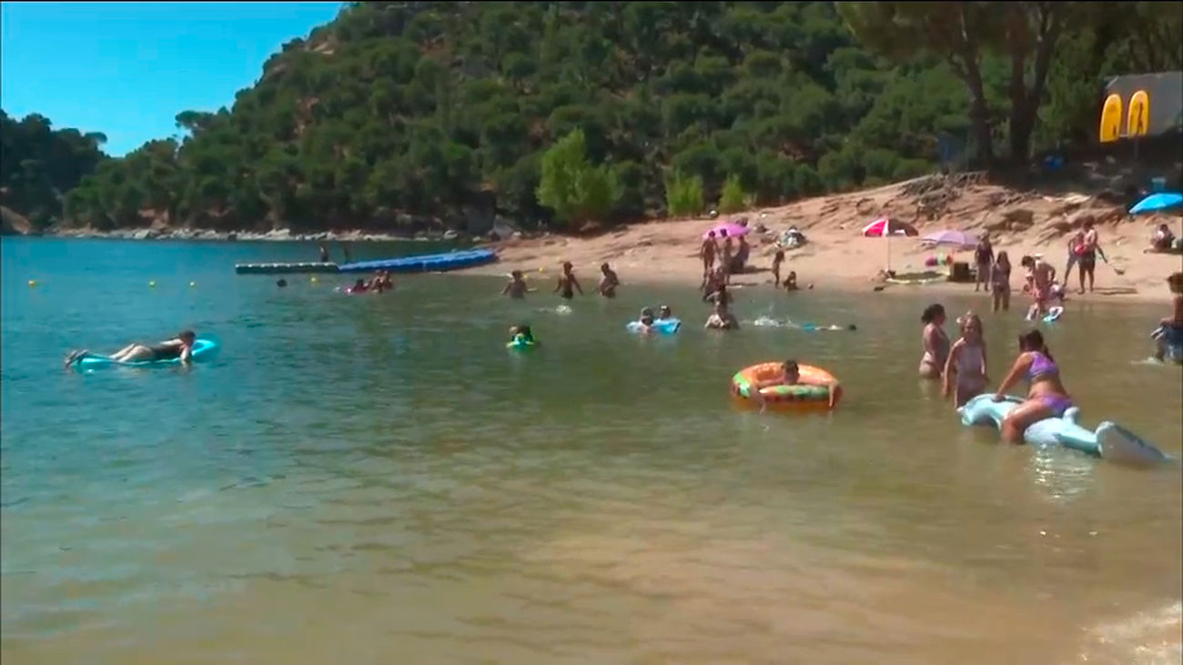 Decenas de madrileños eligen la playa del Pantano de San Juan para disfrutar del verano