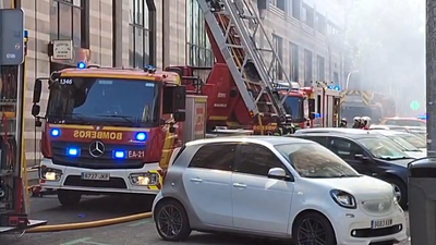 Bomberos trabajan en la extinción de un incendio declarado en un edificio en Ciudad Lineal