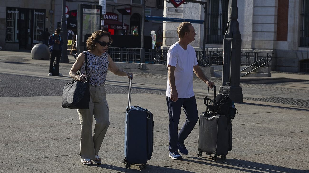 Turistas con maletas en la Puerta del Sol