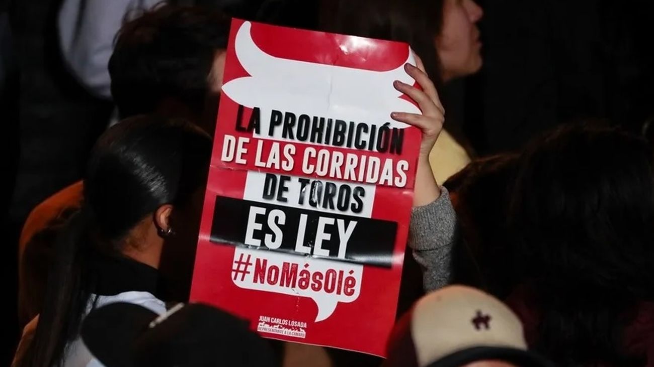 Un hombre sostiene un cartel de apoyo a la prohibición de las corridas de toros en Colombia