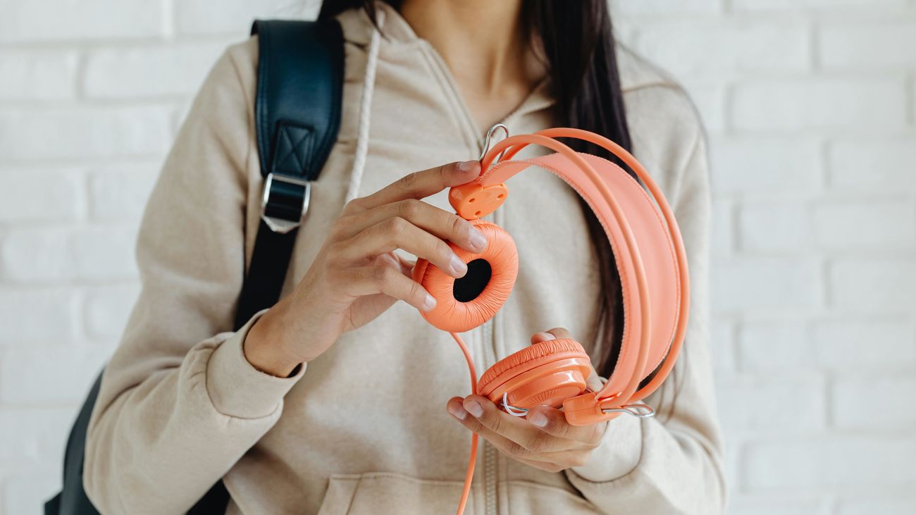 Mujer sujeta unos cascos para escuchar música