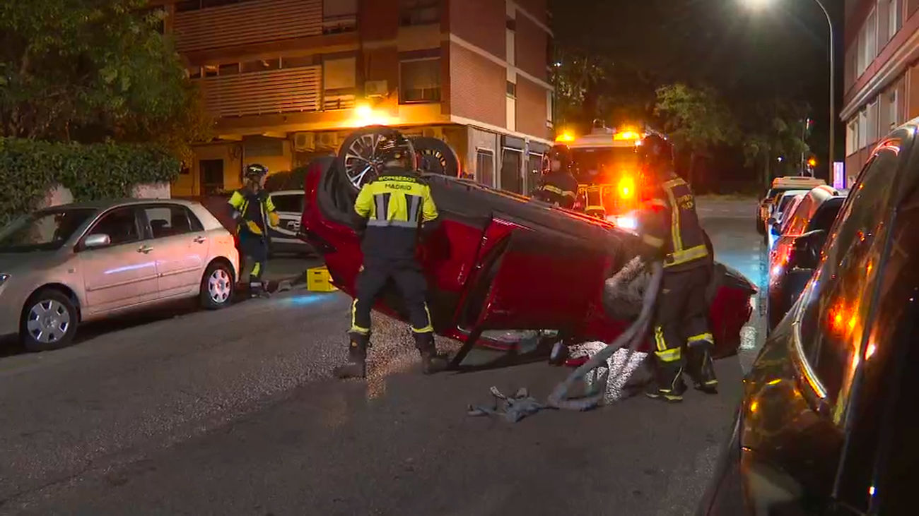 Pierde el control, arrolla a un coche aparcado y termina volcado en la calzada