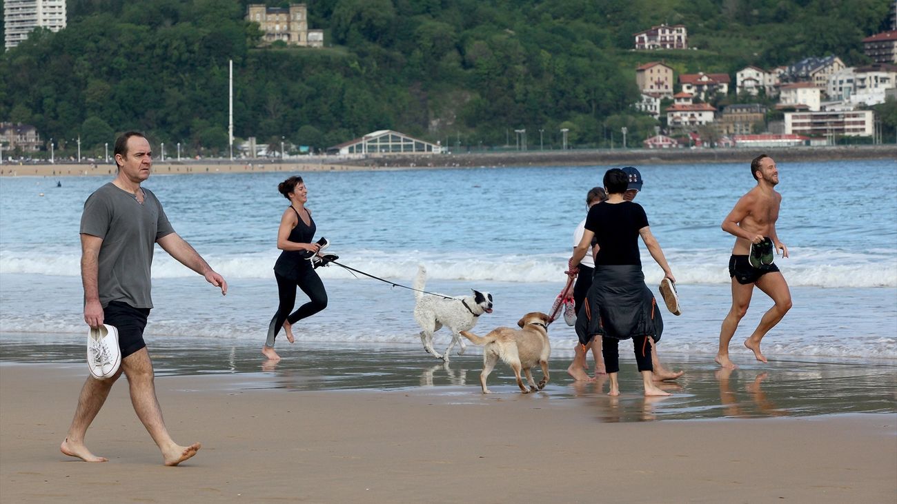 Varias personas pasean por la playa de La Concha en San Sebastián