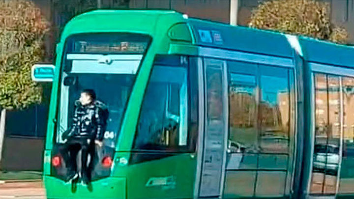 Encaramado en el exterior del tranvía de Parla