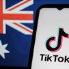 El logotipo de TikTok en la pantalla de un teléfono con la bandera australiana de fondo