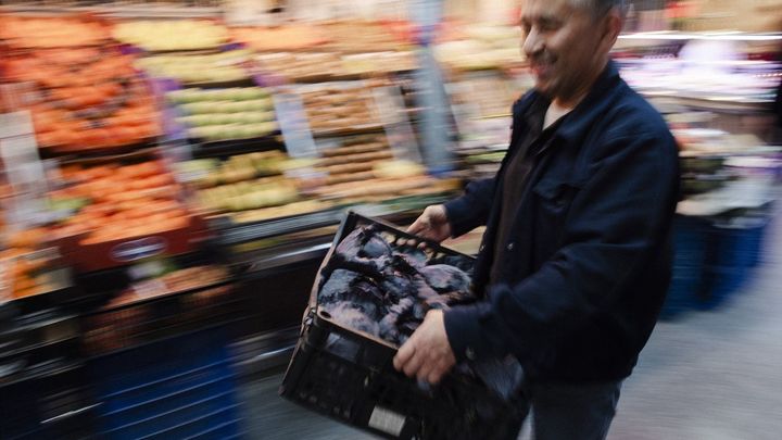 Un tendero trabaja para las personas que realizan sus últimas compras antes de la cena de Nochebuena