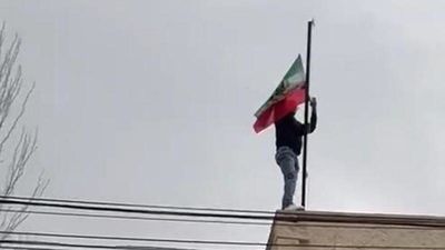 Un activista sustituye la bandera islámica de la embajada de Irán en Madrid por la de 1979